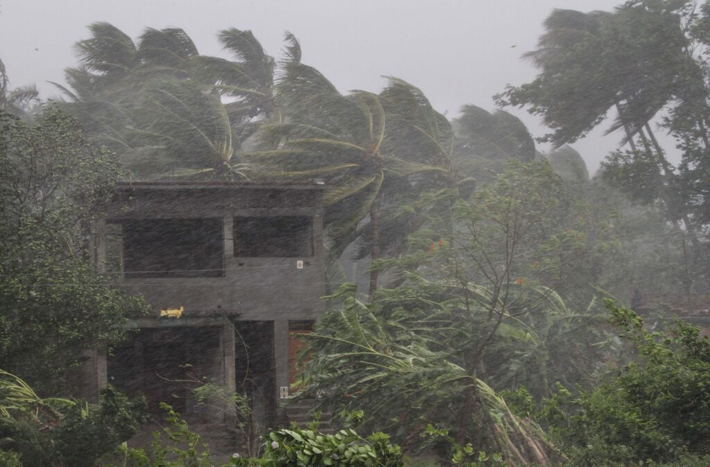 An abandoned house and trees bend with gusty winds ahead off the landfall of cyclone Fani on the outskirts of Puri AP Photo)